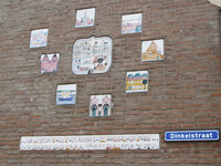 905351 Afbeelding van de door kinderen ontworpen tegelplateaus in de zijgevel van de woning Waalstraat 124 in de ...